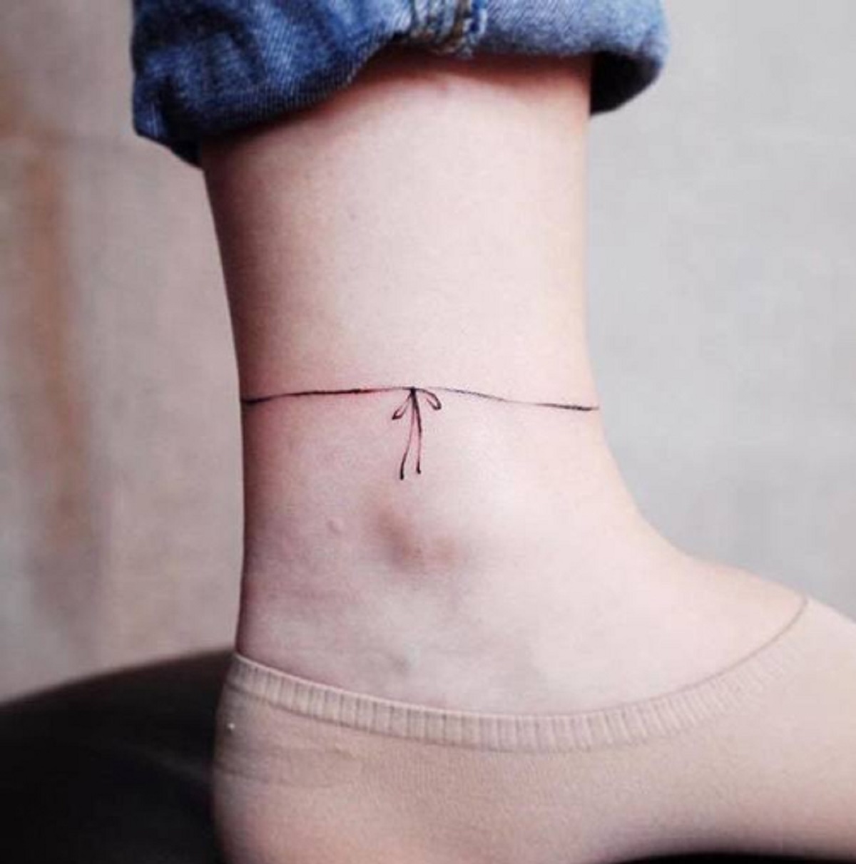Mẫu hình xăm vòng nơ ở cổ chân đơn giản, tinh tế