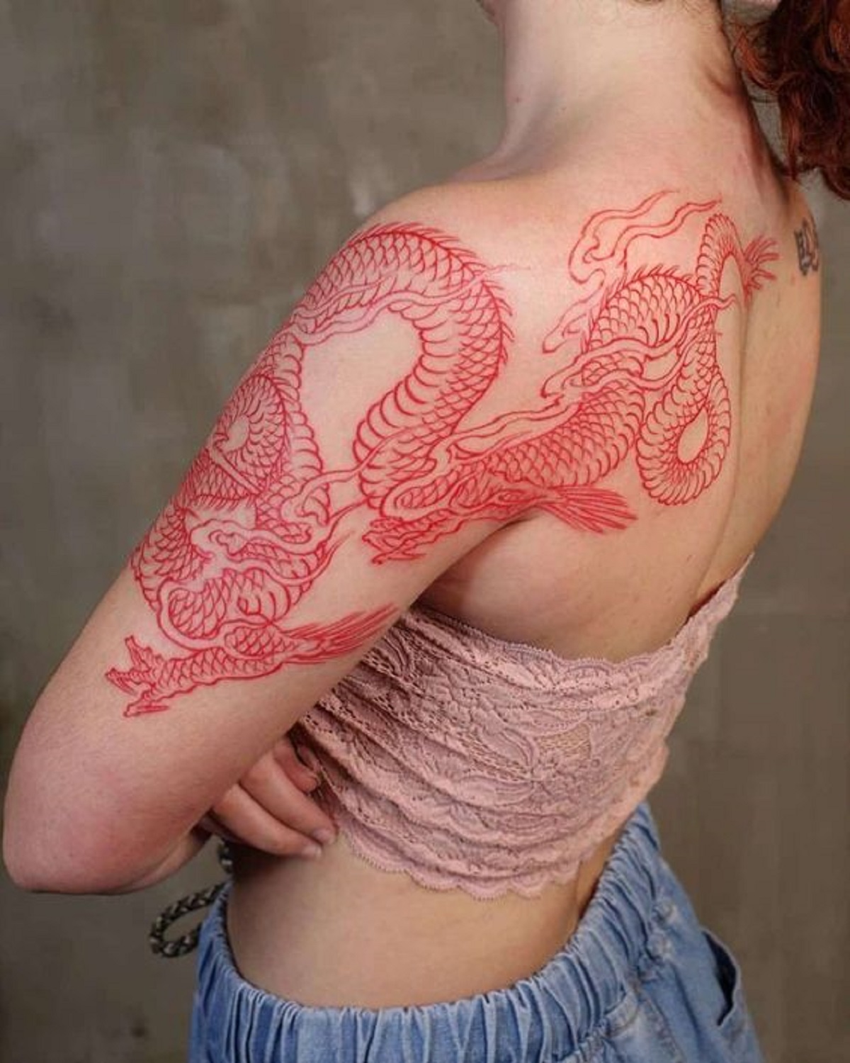 Mẫu hình xăm con rồng đỏ trên bắp tay phụ nữ